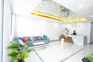 a lobby with a blue couch and a table at SKY HOTEL in Long Thành