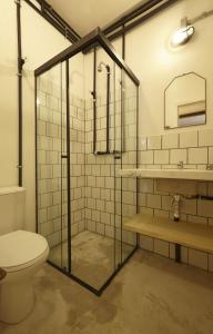 a bathroom with a toilet and a glass shower at Guest Urban Hotel Design Pinheiros in São Paulo +29 photos
