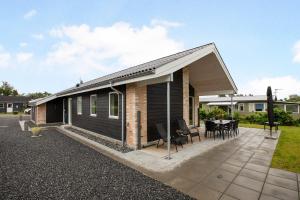 a house with a pitched roof and a patio at Ferie-Oasen i Øster Hurup in Øster Hurup