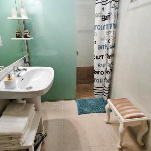 a bathroom with a sink and a shower curtain at Can Carreras de Sant Jaume in Sant Jaume de Llierca
