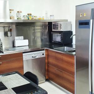 a kitchen with stainless steel appliances and wooden cabinets at Can Carreras de Sant Jaume in Sant Jaume de Llierca
