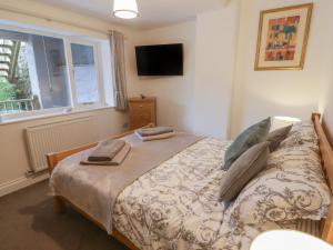 a bedroom with a bed and a window at Le Durkestrete Cellar in Haverfordwest