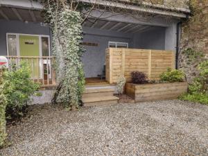 a house with a wooden staircase leading to a porch at Le Durkestrete Cellar in Haverfordwest