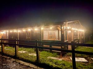 a wooden cabin with lights on it at night at Reindeer Lodge by StayStaycations 