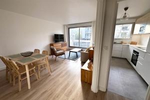 uma cozinha e uma sala de estar com mesa e cadeiras em Courbevoie - Normandie - La Défense em Courbevoie