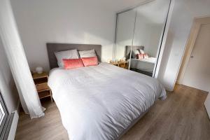 um quarto com uma grande cama branca com almofadas vermelhas em Courbevoie - Normandie - La Défense em Courbevoie