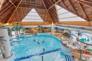 una gran piscina cubierta con gente. en Maison Jade - piscines partagées, en Branville