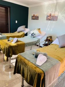 una camera con tre letti con cappelli di Dips And T Hotel & Spa a Bloemfontein