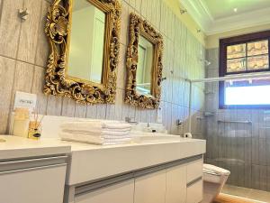 bagno con lavandino e specchio di Villa Maria Pousada de Charme a Brotas