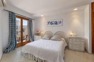 a bedroom with a bed and a dresser and a window at Llenaire 2, Sea view, pool, AC in Port de Pollensa