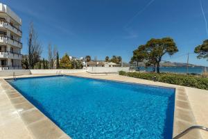 a large blue swimming pool next to a building at Llenaire 2, Sea view, pool, AC in Port de Pollensa