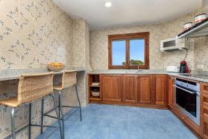 a kitchen with wooden cabinets and a window at Llenaire 2, Sea view, pool, AC in Port de Pollensa
