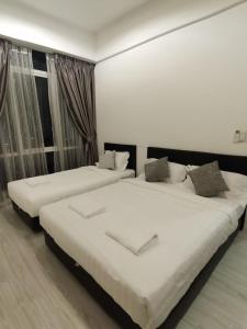 dos camas sentadas una al lado de la otra en un dormitorio en Sutera Avenue - Jom Summer Suite, en Kota Kinabalu