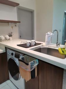 eine Küche mit Spüle und Geschirrspüler in der Unterkunft Sutera Avenue - Jom Summer Suite in Kota Kinabalu