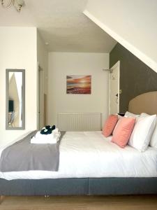 1 cama con almohadas rosas y blancas en una habitación en The Silver How, en Bournemouth