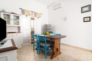 cocina con mesa de madera y sillas azules en Casa Masala Irgoli, en Irgoli