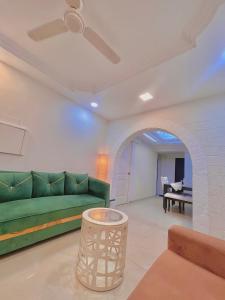 a living room with a green couch and a table at Luxurious stay with home love in Mumbai