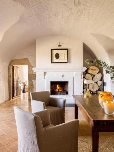 a living room with a fireplace and a table at Mas de Torrent Hotel & Spa, Relais & Ch&acirc;teaux in Torrent