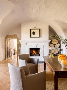 a living room with a fireplace and a table at Mas de Torrent Hotel & Spa, Relais & Châteaux in Torrent