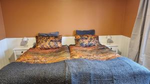 sypialnia z 2 łóżkami i kolorowymi kocami w obiekcie Fornilækur Guesthouse w mieście Blönduós