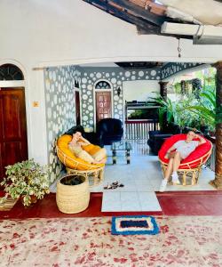 2 personas sentadas en sillas en una sala de estar en Sheran Safari House en Udawalawe