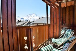 una terraza con sillas y vistas a la montaña en Andromede - 35 - Studio coeur station - 4 pers en Les Deux Alpes