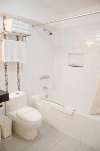 a white bathroom with a tub and a toilet at Hotel Britania Miraflores in Lima