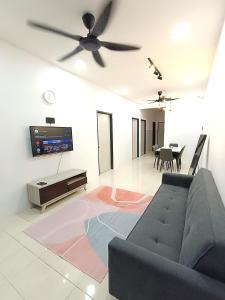 sala de estar con sofá y TV de pantalla plana en Indera Sempurna Ruma Aisya en Kuantan
