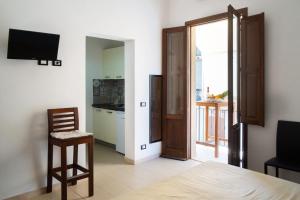 a room with a bed and a television and a kitchen at Appartamenti Leone1 in San Vito lo Capo