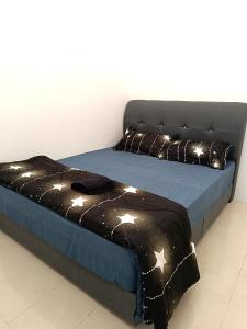 a bed with a black blanket and stars on it at Indera Sempurna Ruma Aisya in Kuantan