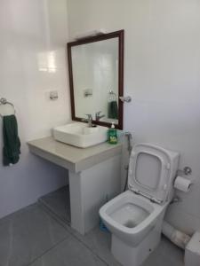 a bathroom with a toilet and a sink and a mirror at Ika homes in Nyali