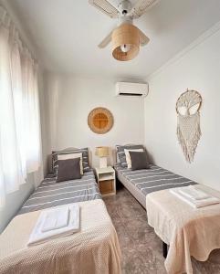 Cette chambre dispose de 2 lits et d'un ventilateur de plafond. dans l'établissement Villa Barma Del Mar, à Torrevieja