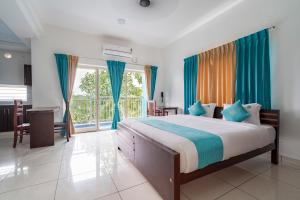 sypialnia z dużym łóżkiem z niebieskimi zasłonami w obiekcie BnB Homes, Technopark, Trivandrum w mieście Kazhakuttam
