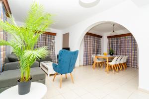 a living room with a blue chair and a table at Kotsias Corallia Villas in Coral Bay