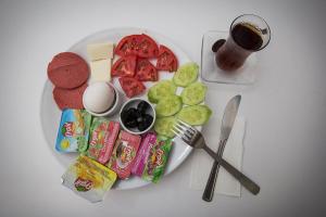 a plate of food with snacks and a glass of beer at 22 OTEL in Edirne