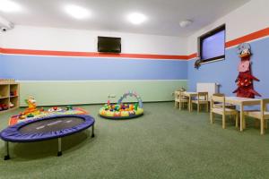a classroom with a play room with a table and chairs at Pension Hollmann in Harrachov
