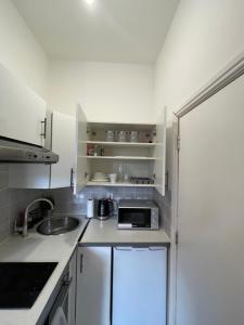 a small kitchen with a sink and a microwave at Camberwell Living Studio - Zone 2 London in London