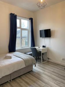 a bedroom with a bed and a desk and a window at Camberwell Living Studio - Zone 2 London in London