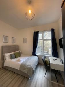 een slaapkamer met een bed, een bureau en een raam bij Camberwell Living Studio - Zone 2 London in Londen