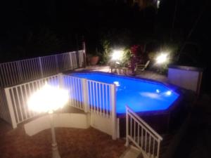 ein Schwimmbad in der Nacht mit zwei Lichtern in der Unterkunft Gites cœur des Antilles in Trois-Rivières