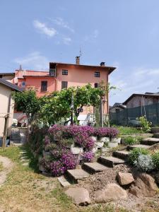 a garden with stairs and flowers in front of a house at Villetta Rosa in Lavena Ponte Tresa