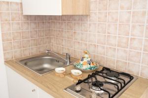 a kitchen counter with a stove and a sink at Camera Tonnarella in San Vito lo Capo