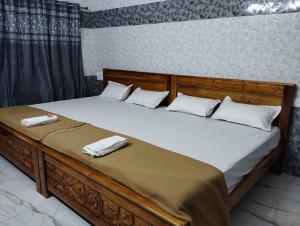 1 cama grande con 2 toallas encima en PRESLEY RESIDENTS en Māvalli