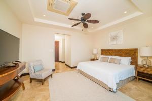 1 dormitorio con 1 cama, TV y silla en AP-7C Azul Paraiso en Ocotal