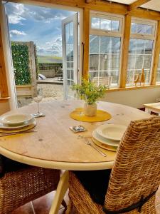 una mesa de madera con 2 sillas y una mesa con gafas en The Lodge, en Kelso