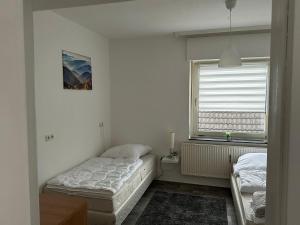 - une chambre avec 2 lits et une fenêtre dans l'établissement Schöne Zimmervermietung für Monteure geeignet ! Direkt am Kanal mit Gartennutzung!, à Hamm