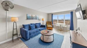 - un salon avec un canapé bleu et une table dans l'établissement Gulf View 1 Unit 403, à South Padre Island