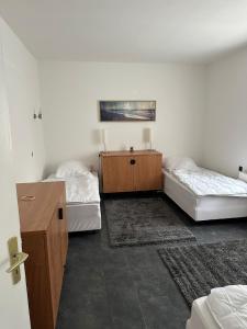 Cette chambre comprend deux lits, une commode et un bureau. dans l'établissement Schöne Zimmervermietung für Monteure geeignet ! Direkt am Kanal mit Gartennutzung!, à Hamm