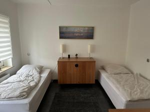 - une chambre avec 2 lits et une armoire en bois dans l'établissement Schöne Zimmervermietung für Monteure geeignet ! Direkt am Kanal mit Gartennutzung!, à Hamm