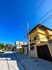 uma rua com um edifício amarelo e uma luz de rua em Pousada Village Rio Centro no Rio de Janeiro